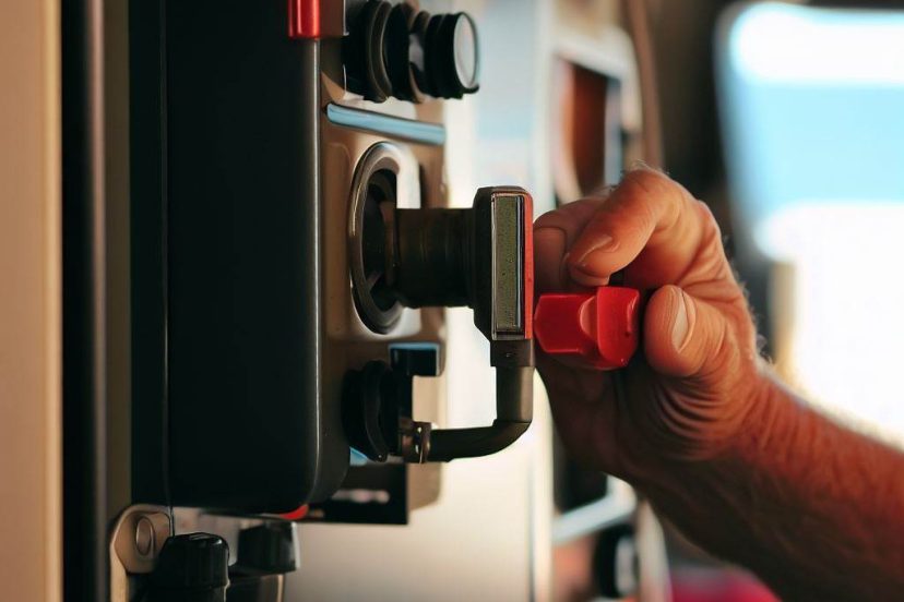 mans hand touching an RV Battery Disconnect Switch