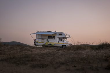 RV at sunset on a grassy dune hill