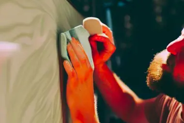 hands with microfiber rag waxing and RV detailing exterior of RV